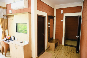 Hotel room interior at Parijatha Inn Dharmasthala — bed and furnishings