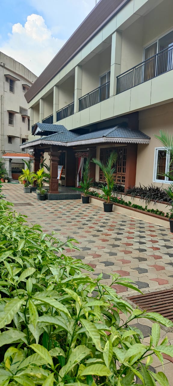 Front view of Hotel Parijatha Inn Dharmasthala — multi-story building with traditional architecture